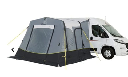 The Trigano Bali inflatable awning is shown with the panels closed, attached to a van with a white background.