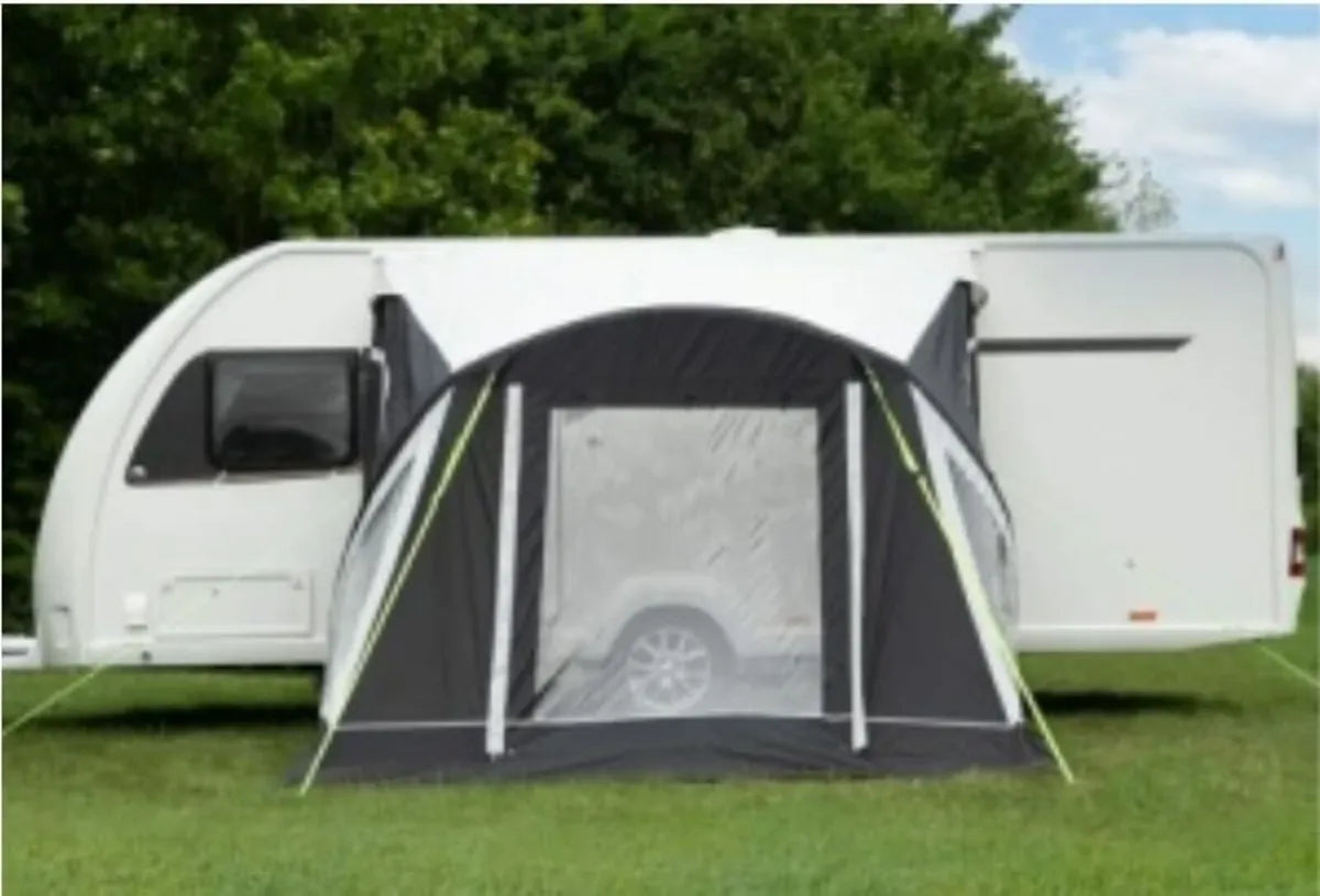 The Baywatch 300 Air Awning is connected to a caravan, in the front view.